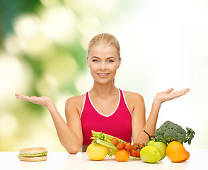 Image showing smiling woman with fruits and hamburger