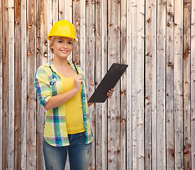 Image showing smiling woman in helmet with clipboard