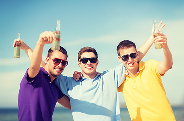 Image showing friends on the beach with bottles of drink