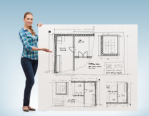 Image showing smiling young woman with white board and blueprint