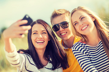 Image showing group of friends taking picture with smartphone