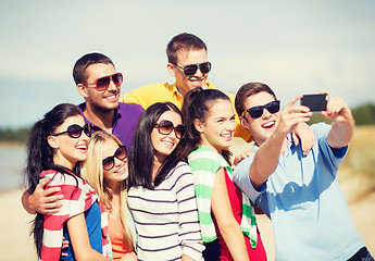 Image showing group of friends taking picture with smartphone