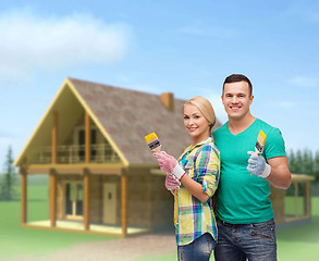 Image showing smiling couple with paintbrush