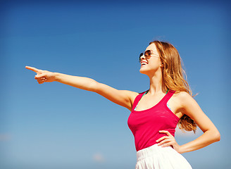 Image showing girl showing direction on the beach