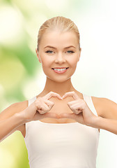 Image showing smiling woman showing heart shape gesture