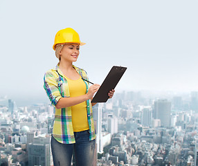 Image showing smiling woman in helmet with clipboard