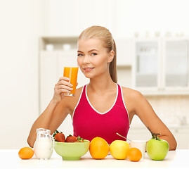 Image showing smiling young woman eating healthy breakfast