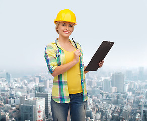 Image showing smiling woman in helmet with clipboard