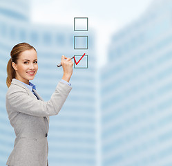 Image showing businesswoman writing something in air with marker