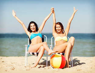 Image showing girls sunbathing on the beach chairs