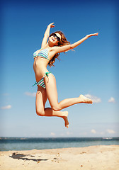 Image showing woman in bikini jumping on the beach