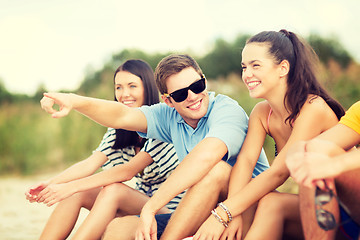 Image showing group of friends pointing somewhere on the beach