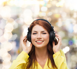 Image showing smiling young girl in headphones at home