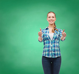 Image showing young woman in casual clothes showing thumbs up