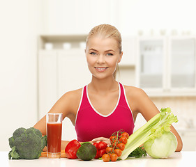 Image showing smiling young woman with organic food on the table