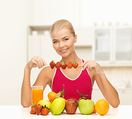 Image showing smiling young woman with organic food on the table