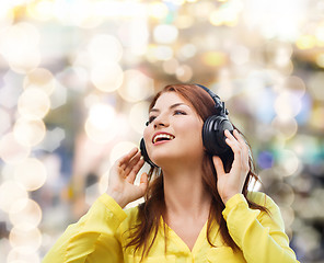 Image showing smiling young girl in headphones at home