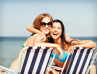 Image showing girls sunbathing on the beach chairs