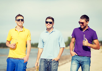 Image showing friends on the beach with bottles of drink