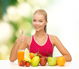 Image showing smiling woman with organic food or fruits on table