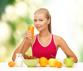 Image showing smiling young woman eating healthy breakfast