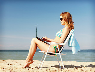 Image showing girl looking at tablet pc on the beach