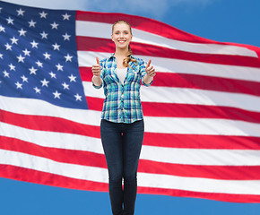 Image showing young woman in casual clothes showing thumbs up