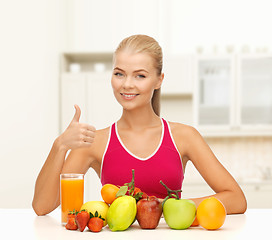 Image showing smiling woman with organic food or fruits on table