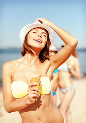 Image showing girl in bikini eating ice cream on the beach