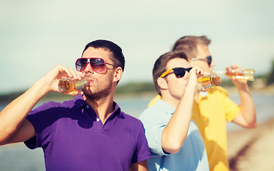 Image showing friends on the beach with bottles of drink