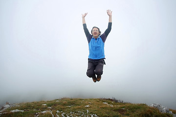 Image showing Man jumping on mountain peak