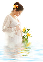 Image showing pregnant woman with yellow lily in water