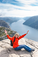 Image showing Woman sitting on Pulpit Rock / Preikestolen, Norway