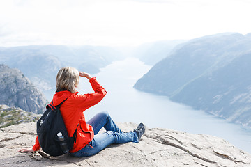 Image showing Woman sitting on Pulpit Rock / Preikestolen, Norway