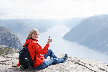 Image showing Woman sitting on Pulpit Rock / Preikestolen, Norway