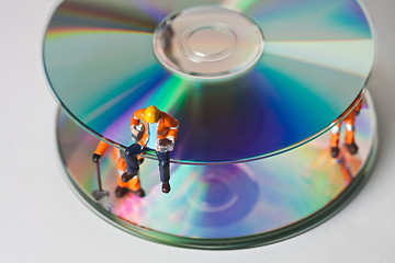 Image showing Miniature people in action with CDs