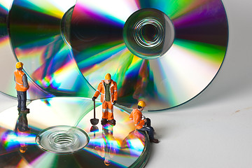 Image showing Miniature people in action with CDs