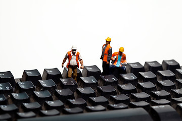 Image showing Miniature people in action on a computer keyboard