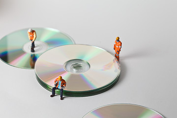 Image showing Miniature people in action with CDs