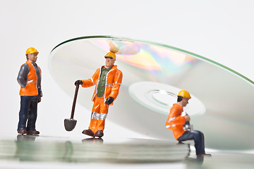 Image showing Miniature people in action with CDs