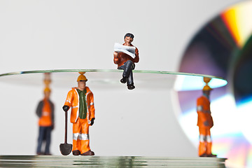 Image showing Miniature people in action with CDs