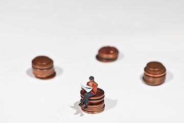 Image showing Miniature people sitting on coins