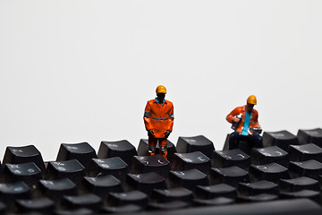 Image showing Miniature people in action on a computer keyboard