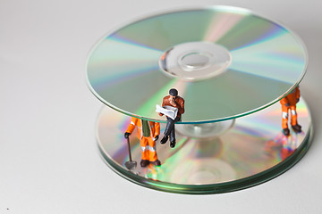 Image showing Miniature people in action with CDs