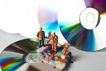 Image showing Miniature people in action with CDs