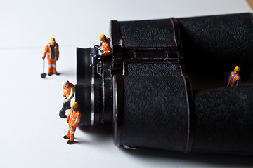 Image showing Miniature people in action with magnification glasses