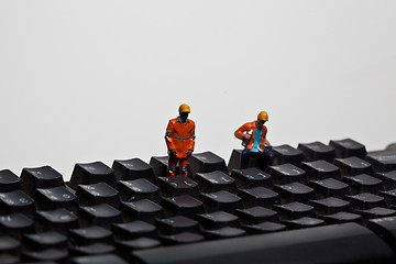 Image showing Miniature people in action on a computer keyboard