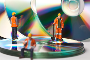 Image showing Miniature people in action with CDs