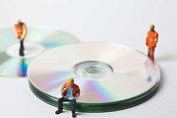 Image showing Miniature people in action with CDs