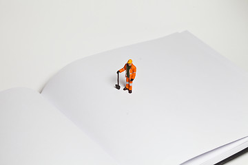 Image showing Miniature people in action worker on an open book